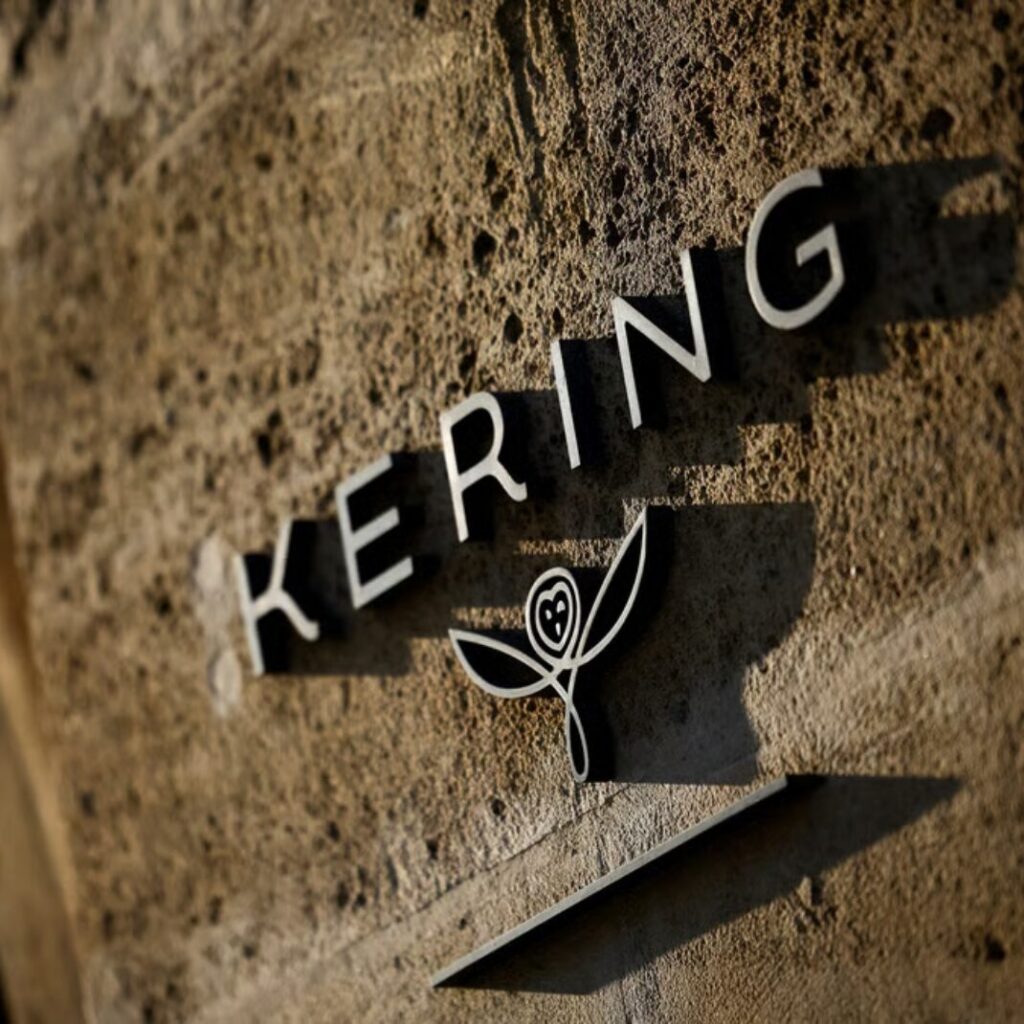 sle logo Kering sur un mur de pierres naturelles